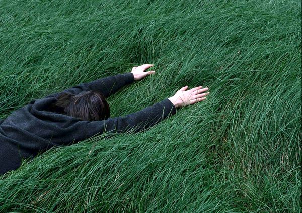 A person lying facedown to the grass